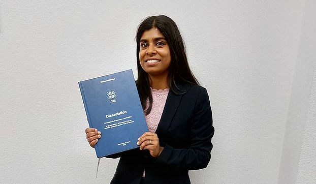 Thanu Korn mit Dissertations-Urkunde