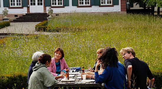 Gruppe isst im Garten vor der Sandgrube