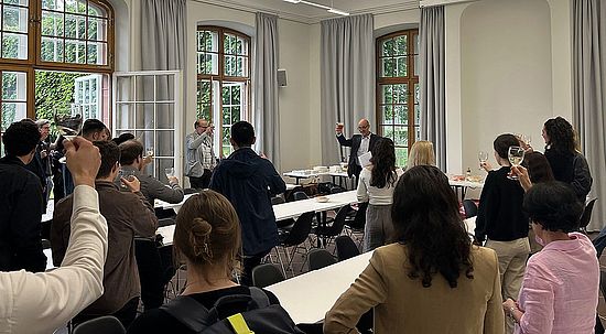 Direktor Ross stösst mit Anwesenden an