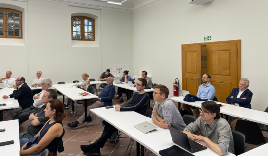 Teilnehmende des Europakolloquiums sitzen im Raum auf Stühlen hinter den Tischreihen